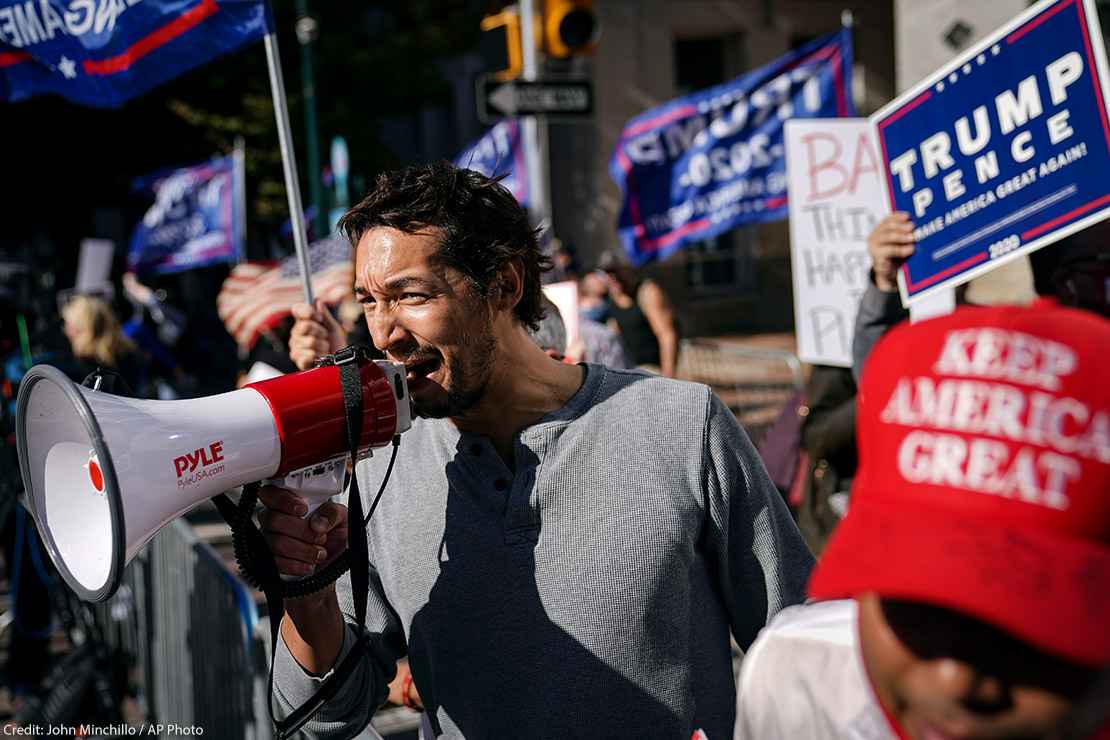 A man uses a bullhorn as he demonstrates with supporters of Donald Trump outside the Pennsylvania Convention Center 