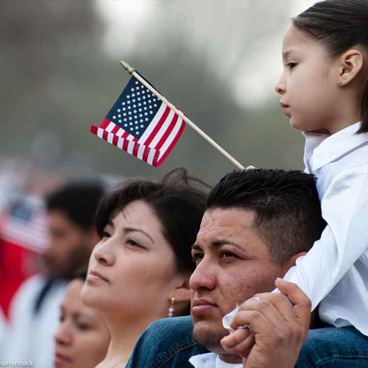 A girl and her father stand with some 200,000 immigrants' rights activists flood the National Mall to demand comprehensive immigration reform on March 21, 2010 in Washington DC.