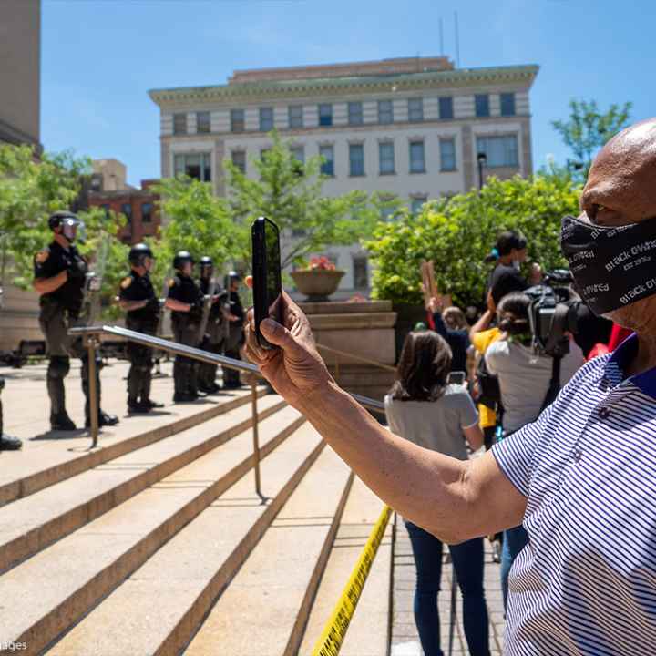 Man recording a line of police people