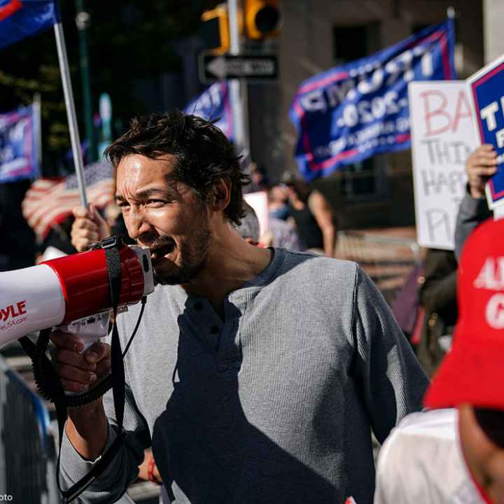 A man uses a bullhorn as he demonstrates with supporters of Donald Trump outside the Pennsylvania Convention Center 