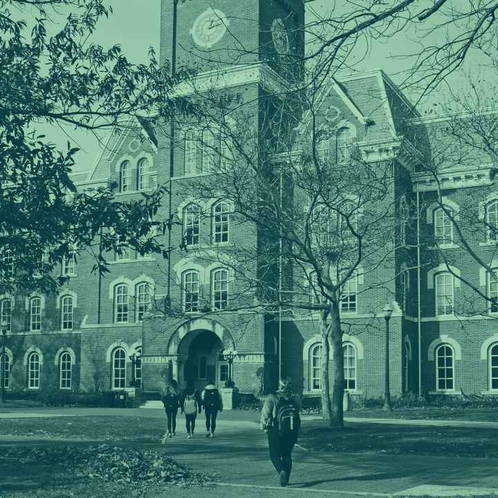 Green tinted picture of students walking on a college campus.