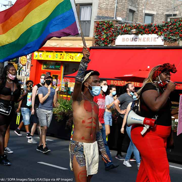 Trans activists march at the Black Transnational Rally with a rainbow flag in the West Village of Manhattan.